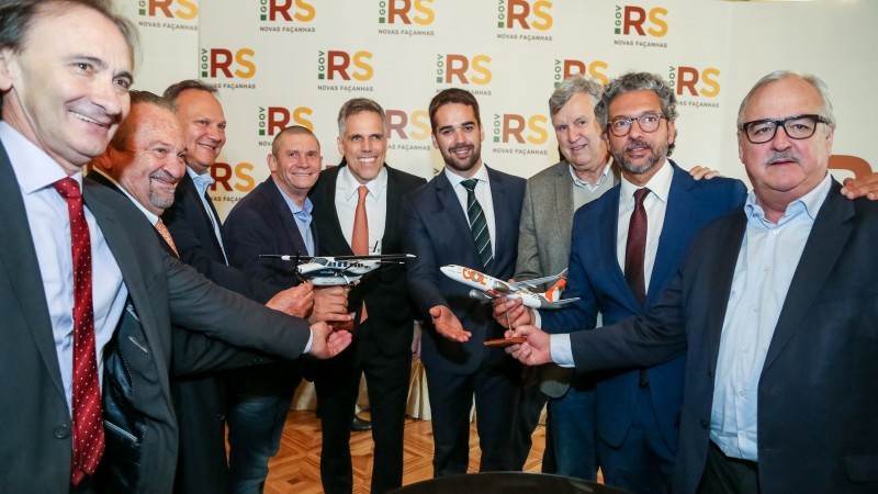 A foto mostra o governador Eduardo Leite, os diretores das empresas Gol e Two Flex, o secretário de Logística e Transportes, o deputado estadual Frederico Antunes e o deputado federal Pedro Westphalen posando com miniaturas de aviões.