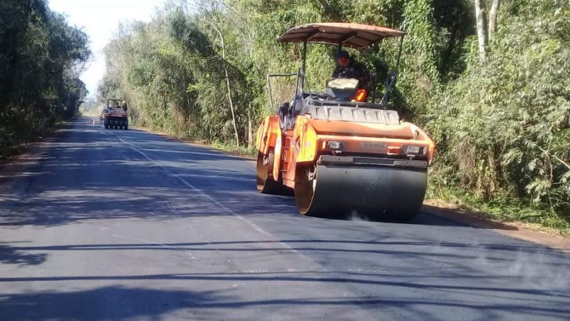 A foto mostra duas patrolas em obras de pavimentação de uma rodovia