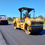 Duas máquinas aplainam pista de asfalto 