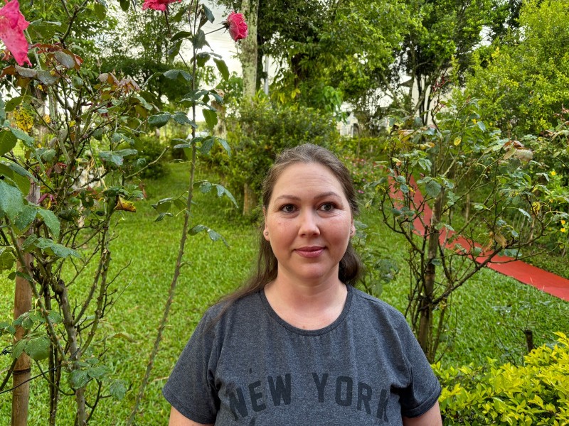 Foto de Tatiane Azambuja Dalla Lana que é moradora de São Martinho, no Rio Grande do Sul. Ela é uma mulher jovem com cabelos castanhos compridos, parcialmente presos, e usa uma camiseta cinza.