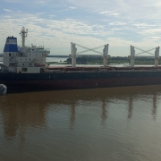 Na imagem há um grande navio de cargas navegando pelo Guaíba. 