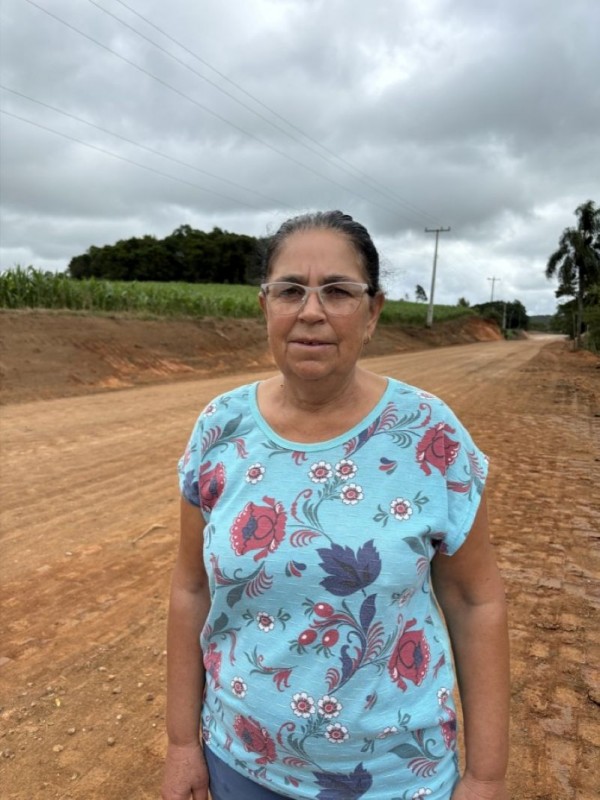 Na imagem está Ana Lucia Pogorzlski, uma mulher branca com cabelos castanhos presos e que veste camiseta azul floreada e óculos discretos.