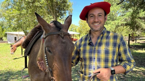 Fabrício Bittencourt sorri para a foto e ao lado dele está um cavalo crioulo.